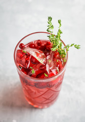 Christmas cocktail with berries and thyme on the rustic background. Selective focus.
