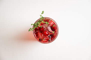 Christmas cocktail with berries and thyme on the rustic background. Selective focus.