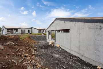 Fototapeta na wymiar Construction of building of new white concrete house with .incomplete wooden roof