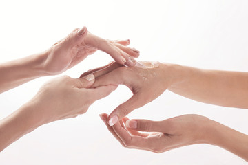 Beauty salon, applying moisturizing cream onto the hands and massaging