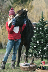 Woman and her horse outdoor. Christmas mood. Happy woman enjoy Christmas magic in garden. 