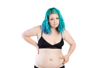 Fat girl. Sad overweight young woman pinching her fat midriff, abdomen. Pot belly, diet, weight problem
