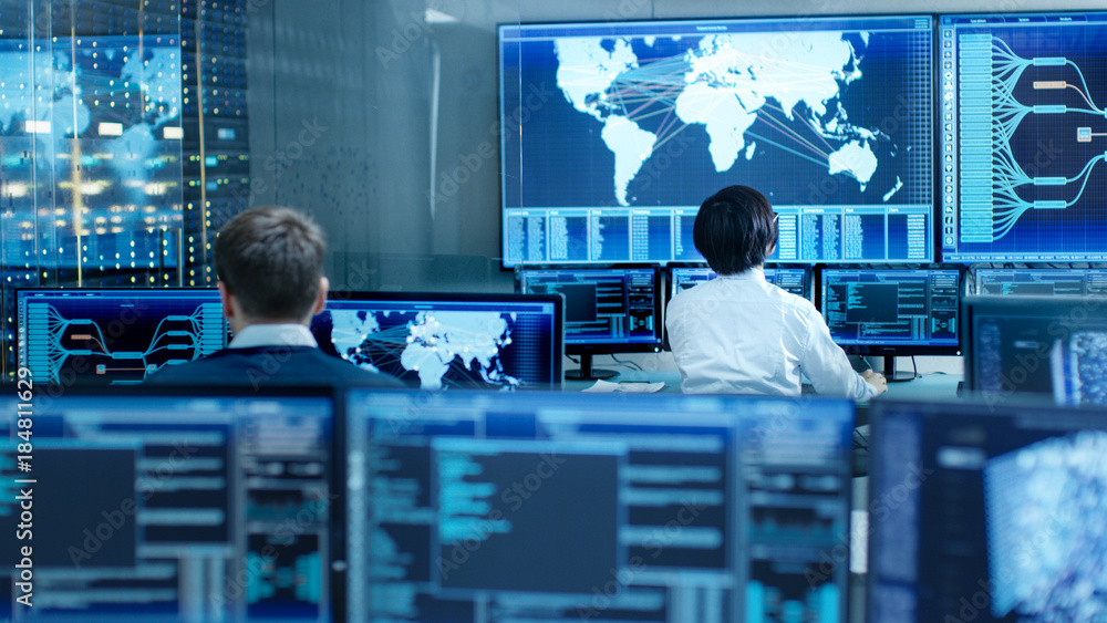 Aufkleber In the System Control Room Operator and Administrator Sitting at Their Workstations with Multiple Displays Showing Graphics and Logistics Information.