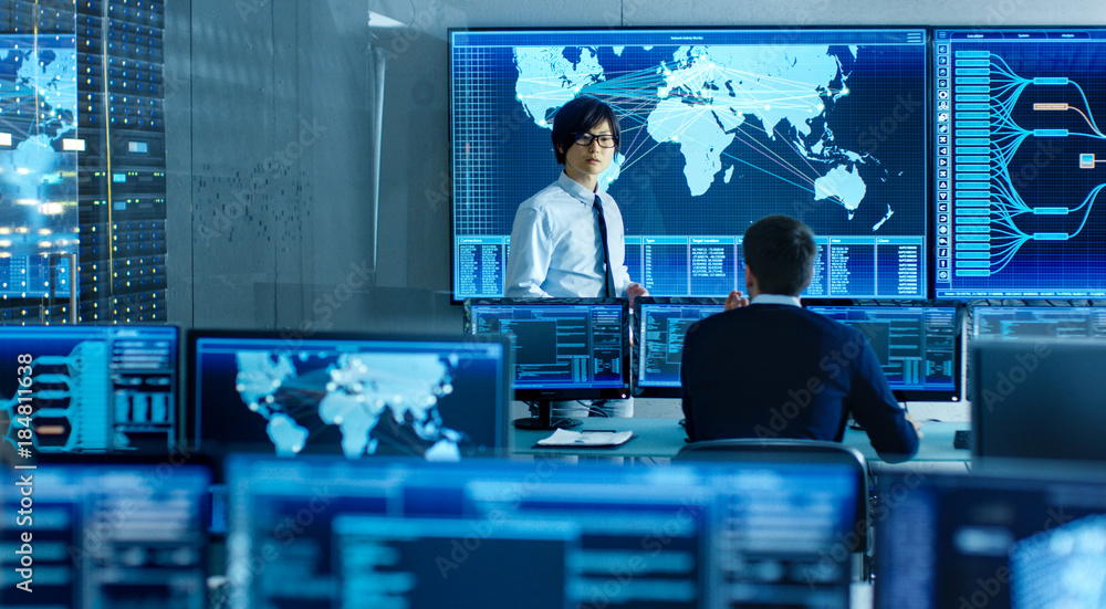 Aufkleber In the System Control Room Manager Holds a Briefing for His Staff Member. They're Work in Data Center and are Surrounded by Multiple Screens Showing Maps, Logistics Data.