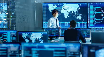 In the System Control Room Manager Holds a Briefing for His Staff Member. They're Work in Data...