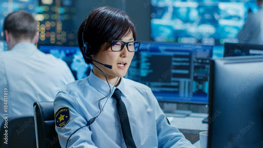 Leinwandbilder In the Security Command Center Officer at His Workstation Monitors Screens and Communicates with Patrols through Headset. He is Part of the Surveillance Team.