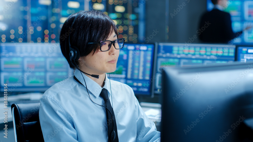 Aufkleber In the Network Operations Center Trader Makes Personal Client Call with a Headset. He's Surrounded by Monitors Showing Stocks Data and Graphs.