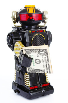 Robot on white background. Classic robot retro toy. . Classical black plastic alloy robot with money. Electronic robotic robot holding money. White background.
