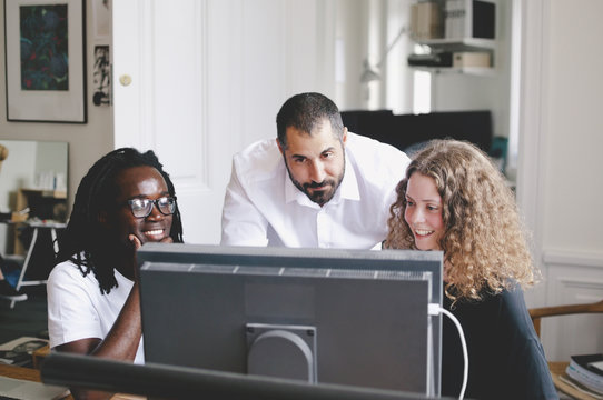 Multi-ethnic business people using computer in creative office