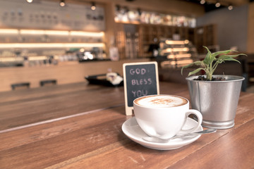 A cup of coffee in relax time on wood table beside mini blackboard with wish text 