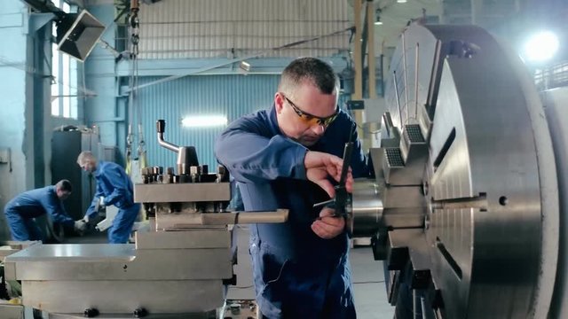 Man using caliper for measuring size detail for working on metalworking machine