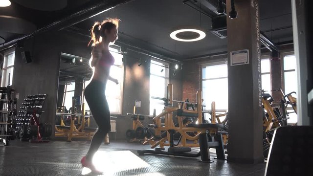Skipping woman training at the gym working out. Fit young woman skipping rope