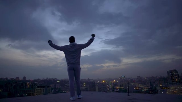 Winner in life enjoying night cityscape, achieving goals, personal leadership