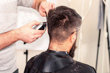 Fototapeta premium Men's hands make the man's haircut a typewriter