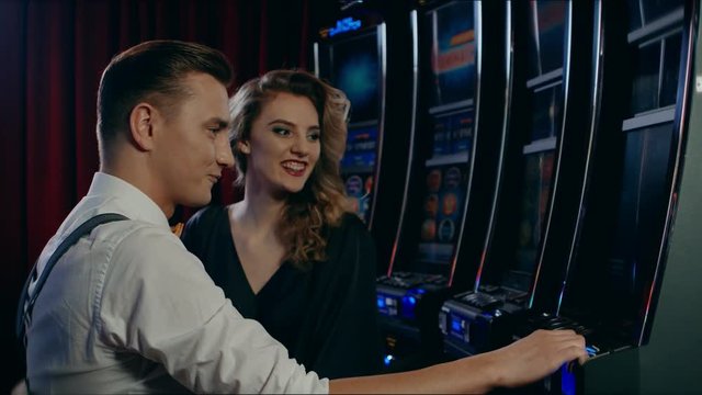 Couple playing slot machine in a casino