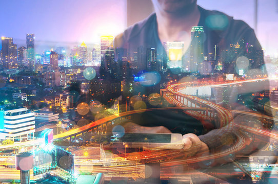 Double Exposure of Man or Male hold Digital Wireless Tablet with Glowing Modern City Scenic