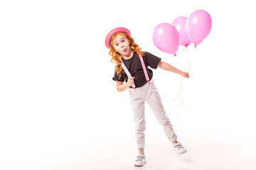 grimacing red hair kid standing with pink balloons on white