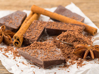 broken pieces of chocolate, anise star, cinnamon sticks, crumb on parchment paper