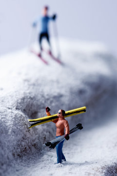 miniature skiers in a snowy landscape