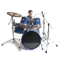 Fototapeta na wymiar young blond boy at drum kit in studio against white background
