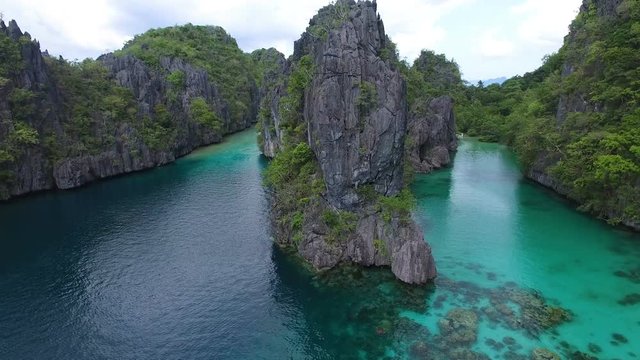 Beautiful cliffs off the Philippines, aerial establishing shot rising above thm