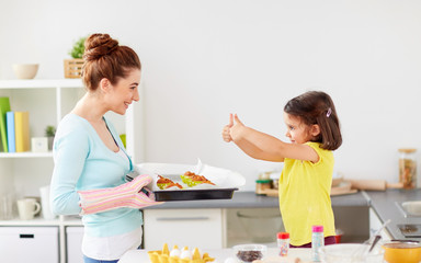 mother and daughter baking muffins at home