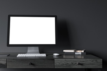 Blank computer screen on a black wooden desk