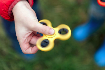Two boys playing fidget spinners. Outdoor.