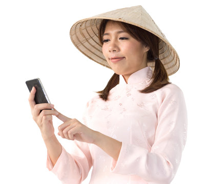 beautiful woman in pink dress and vietnam hat holding smartphone. isolated background with clipping path.