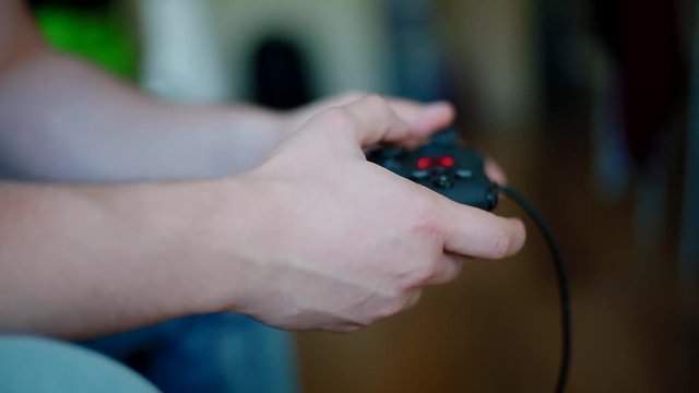 Young man playing on controller. Closeup shot.