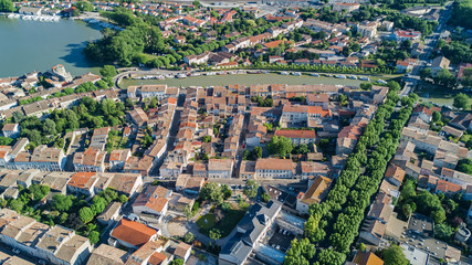 Fototapeta na wymiar Aerial top view of residential area houses roofs, streets and canal with boats from above, old medieval town background, France 