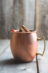 Cold Moscow Mule cocktail in copper mug on the rustic background. Shallow depth of field.