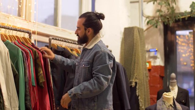 man choosing clothes at vintage clothing store