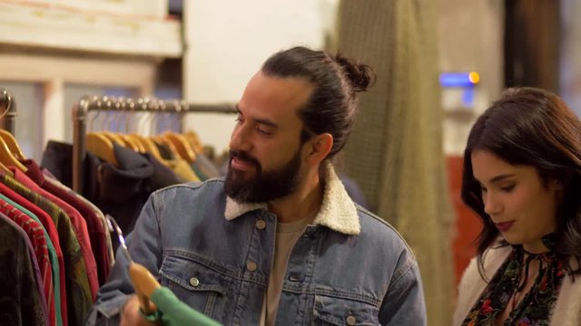 couple choosing clothes at vintage clothing store