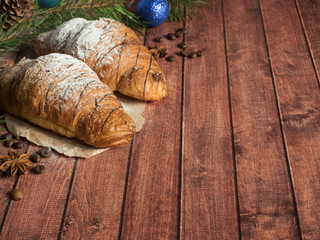 Christmas Breakfast croissant on a napkin. Dark wooden background. Christmas decorations Copy space