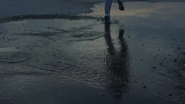 Completely confident in his shoes guy fearlessly running through puddle, quality