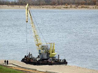 Fototapeta na wymiar Floating excavator on the construction of the new waterfront