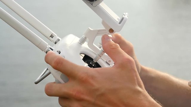 Two male hands using a remote controller, which is used to fly remote controlled drones