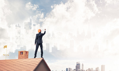 Man architect draw silhouette of modern city on blue sky. Mixed 