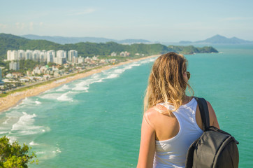 ótimo conceito de viajante, mochileiro, viajar, jovem mulher observando praia 