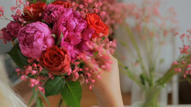 Professional woman floral artist, florist making beautiful wedding bouquet at workshop, flower shop. Close up shot. Floristry, handmade and small business concept