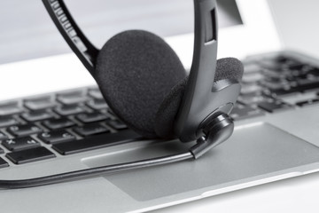 call center support concept. headset on keyboard computer laptop