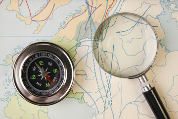 Compass and magnifying glass on map