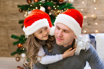 Dad and daughter, Christmas hat, tree, gift box