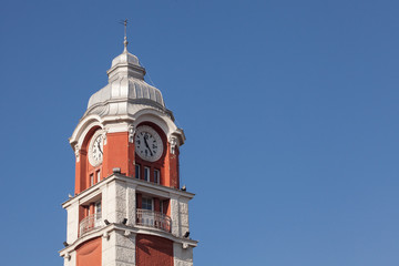 Fototapeta na wymiar Varna train station clock tower, against blkue sky. Architecture detail from Varna, the sea capital of Bulgaria.