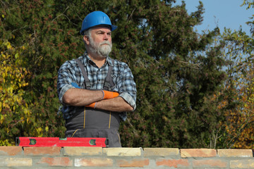 Worker or engineer control brick wall using level tool, real people, no retouch