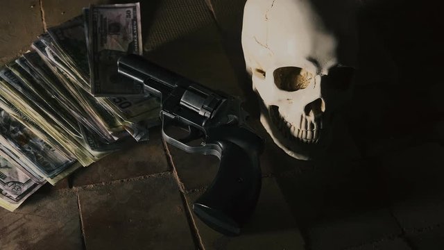 money and a revolver near the skull. Criminal concept