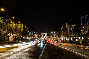 Avenue Champs-Elysees with Christmas illumination and Arc de Triomphe at background in Paris, France. 