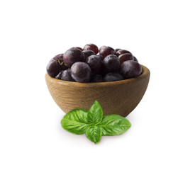Grapes ith basil in a wooden bowl isolated on white background. Purple grapes with copy space for text. egetarian or healthy eating.