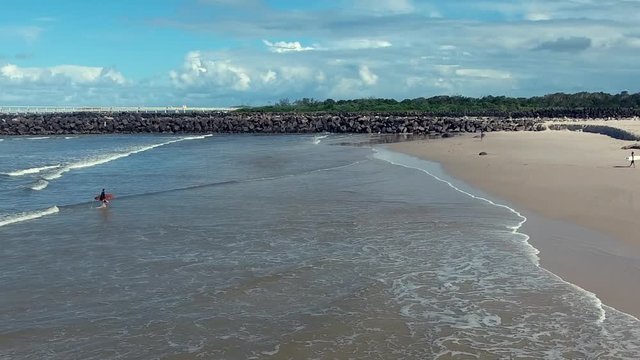 surfers walking on the beach aerial view